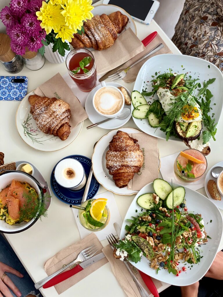 Frühstückstisch mit Croissants, Salat, Avocado und Kaffee