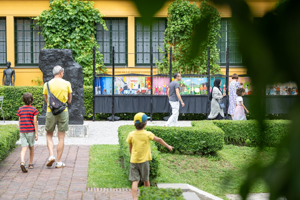 Familien entdecken selbst gestaltete Figurenbilder im Garten des Lenbachhauses beim Kunstareal-Fest München, kostenlose Figurentheater-Werkstatt für Kinder und Jugendliche