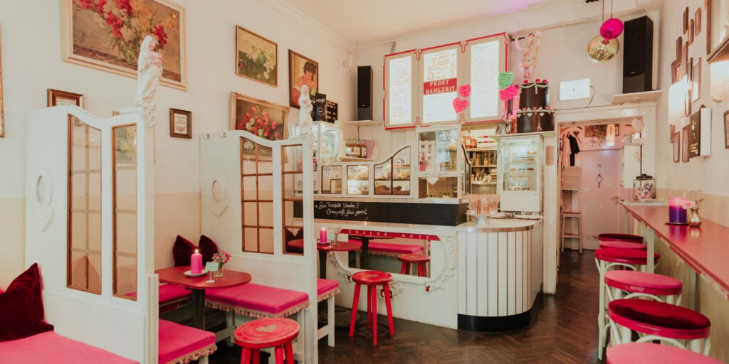 Zuckersüßer Gastraum des Café Fräulein mit rosa Hockern und Blumenschmuck