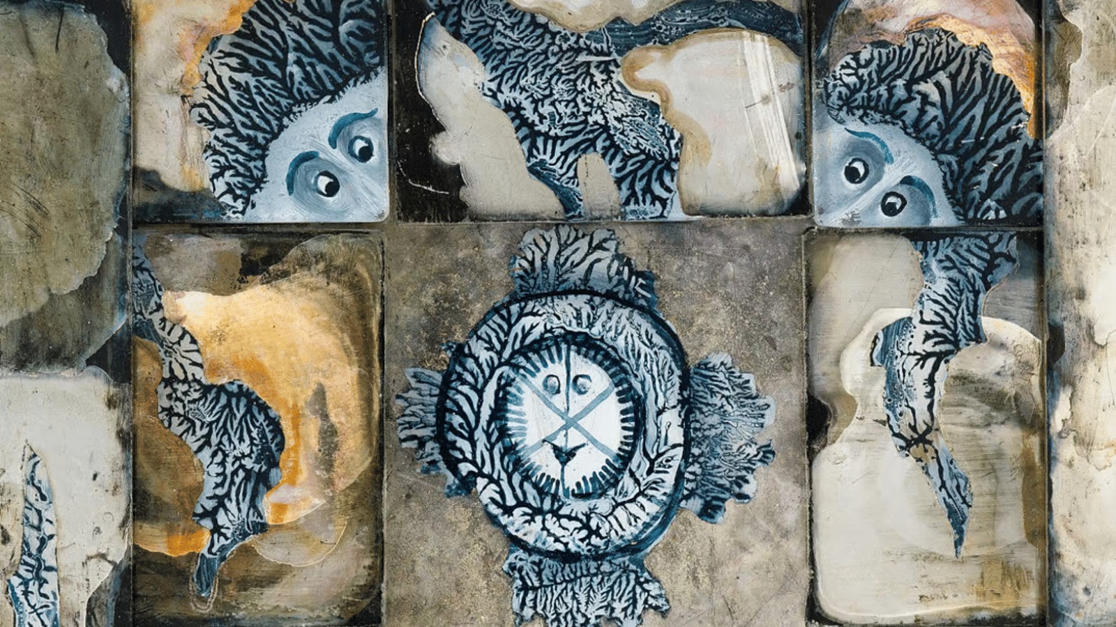 Wall mural of interlocking tile squares with blue coral patterns and a central round emblem resembling a face or badge.