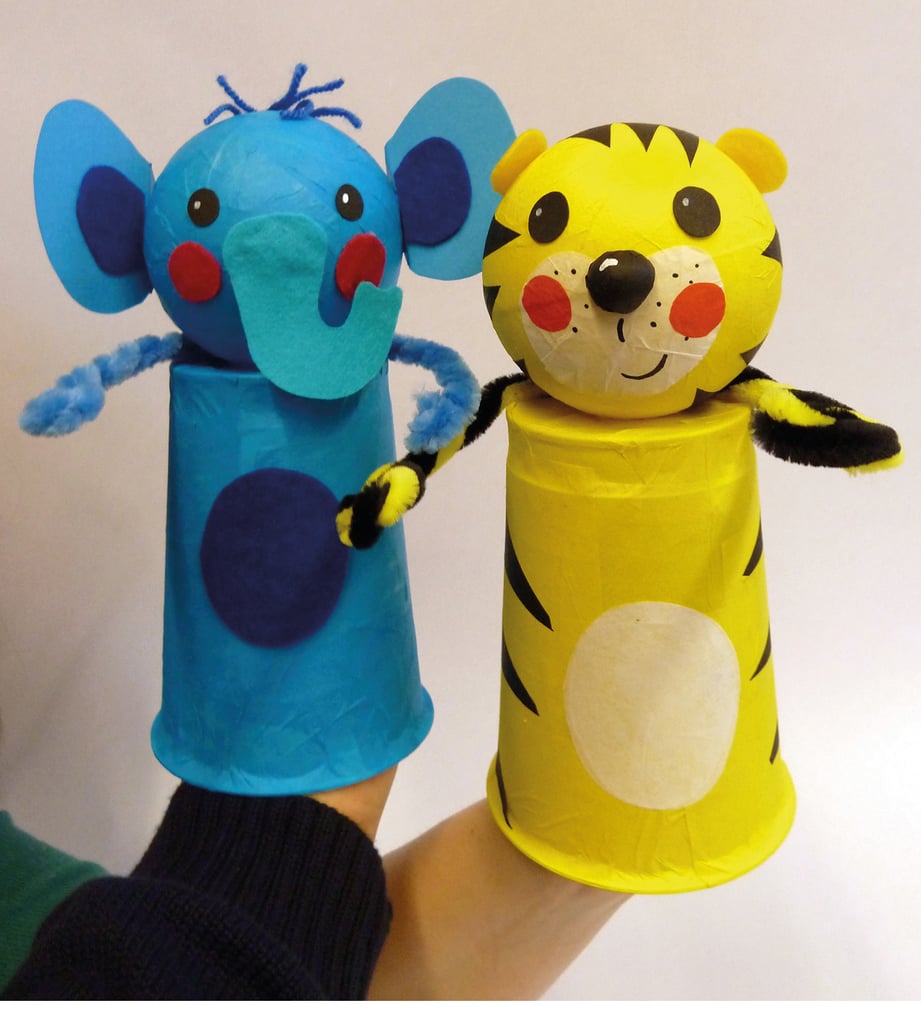 Blue elephant and yellow tiger hand puppets on sticks, held up for a puppetry show against a plain background.