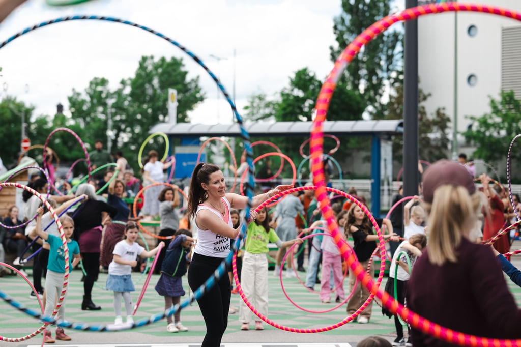 Kinder und Erwachsene tanzen und üben mit bunten Hula-Hoops beim Tanz den Gasteig Festival in München
