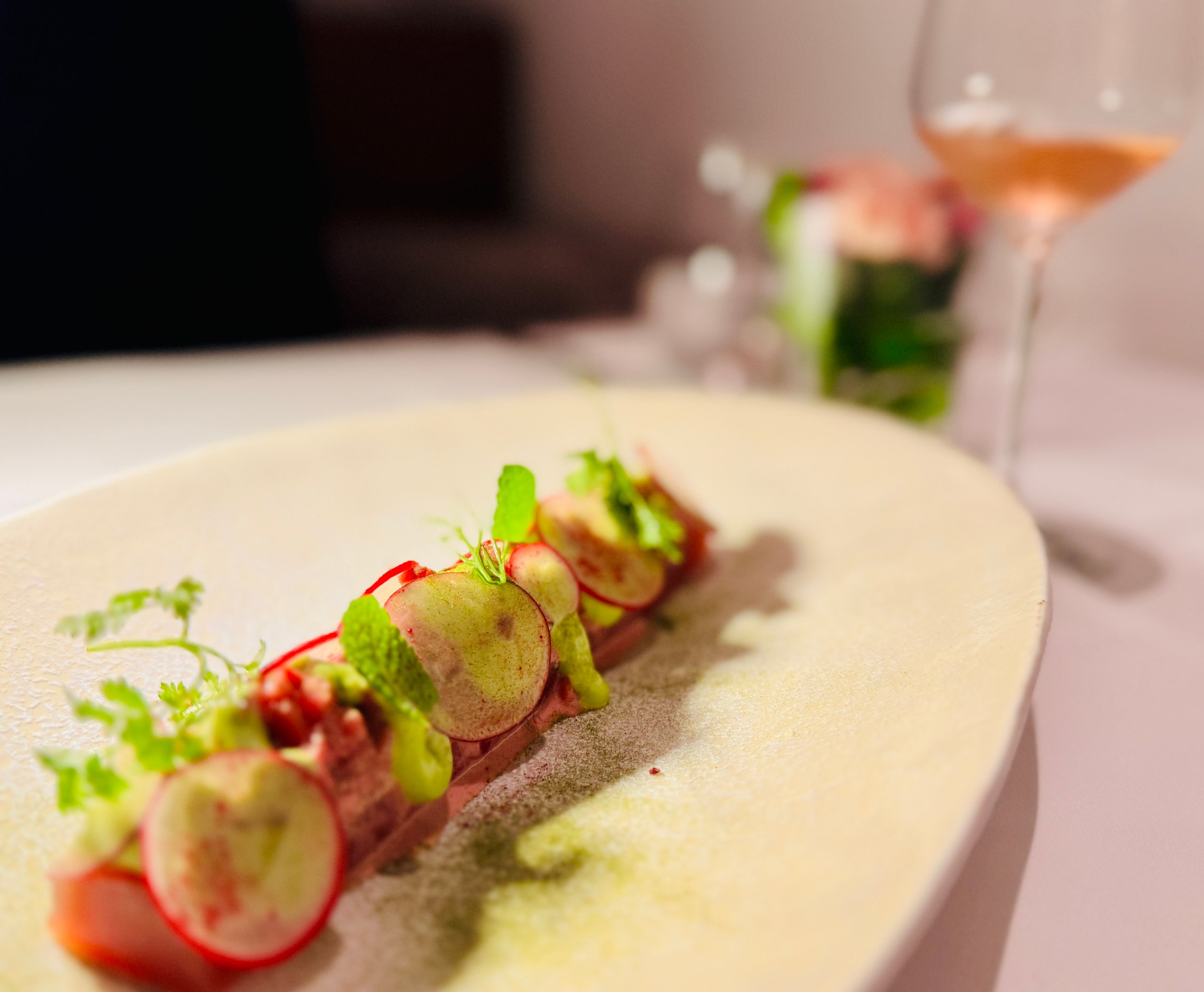 Thunfisch-Tranchen mit Radieschen-Salat, Dill und Minzblättchen auf einem Teller