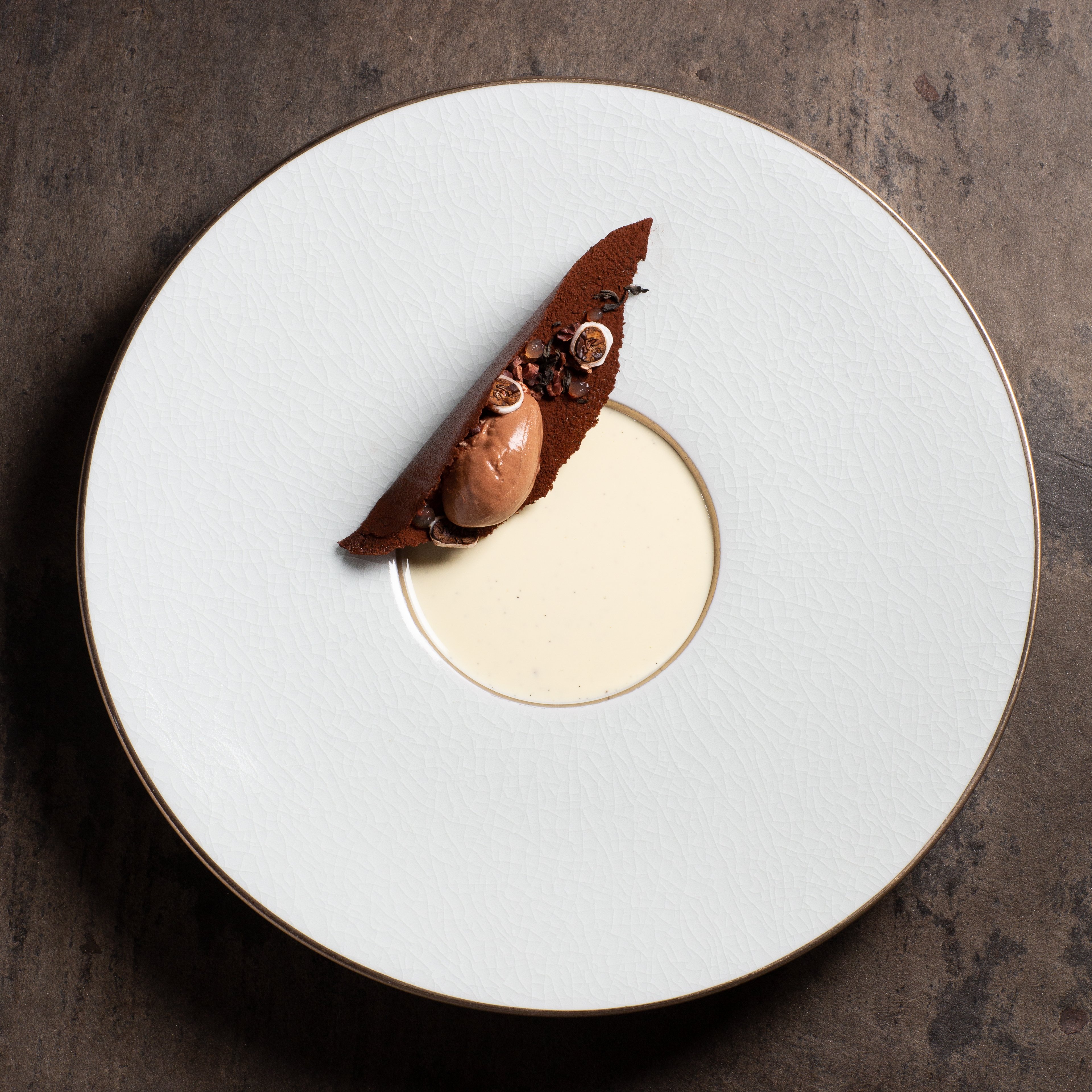 Schokoladendessert mit heller Creme auf weißem Teller