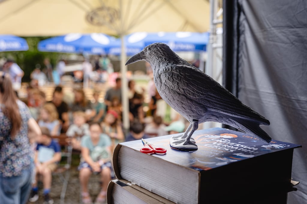 Papier-Rabe auf einem Bücherstapel beim White Ravens Festival für Kinder- und Jugendliteratur im Schloss Blutenburg München