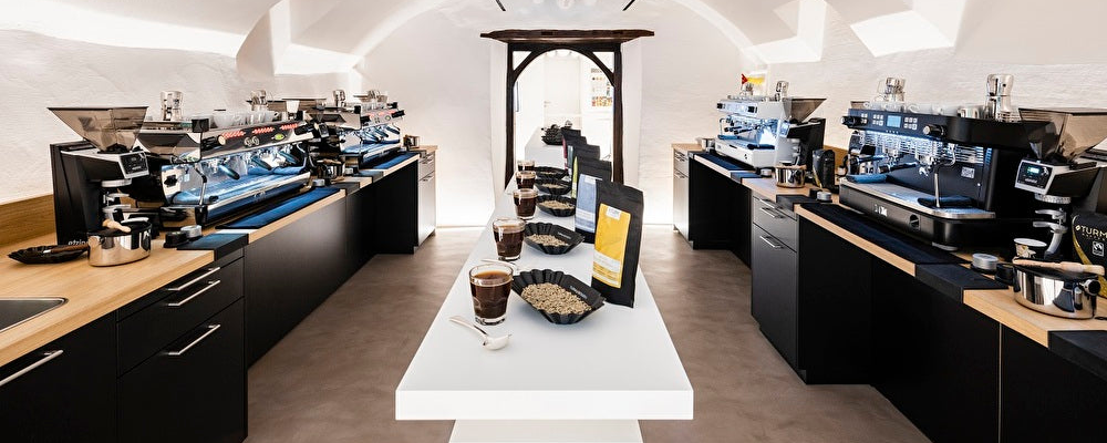 Gewölberaum der Barista Academy von Turm Kaffee mit Espressomaschinen auf schwarzen Theken