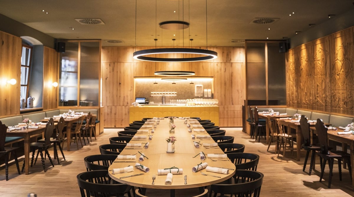 Gastraum des Wirtshauses mit langer Tafel in der Mitte