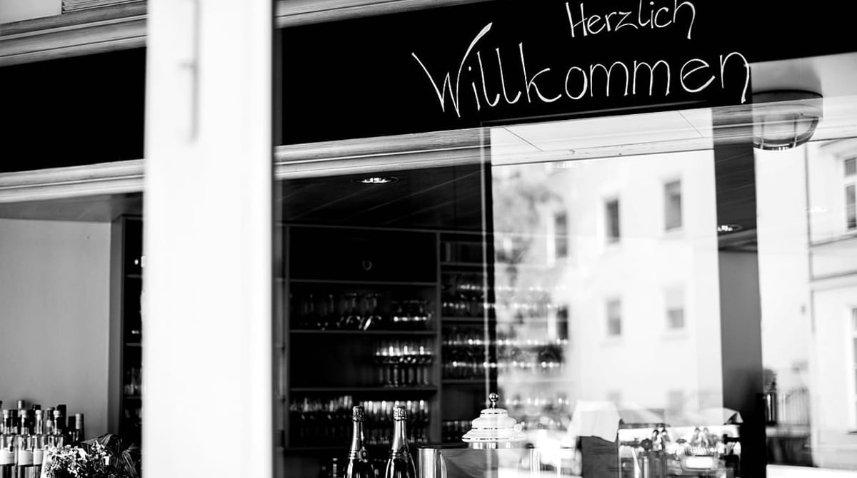 Eingang des Le Stollberg mit „Herzlich Willkommen“ auf der Glastür