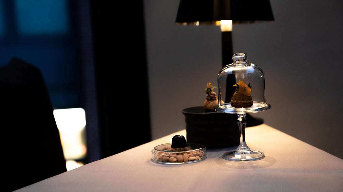 Tischlampe und Glasglocke auf einem gedeckten Tisch im Les Deux