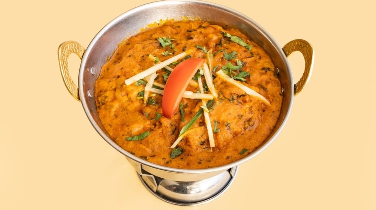 Fisch Masala in der Messingschale mit Tomate und Koriander