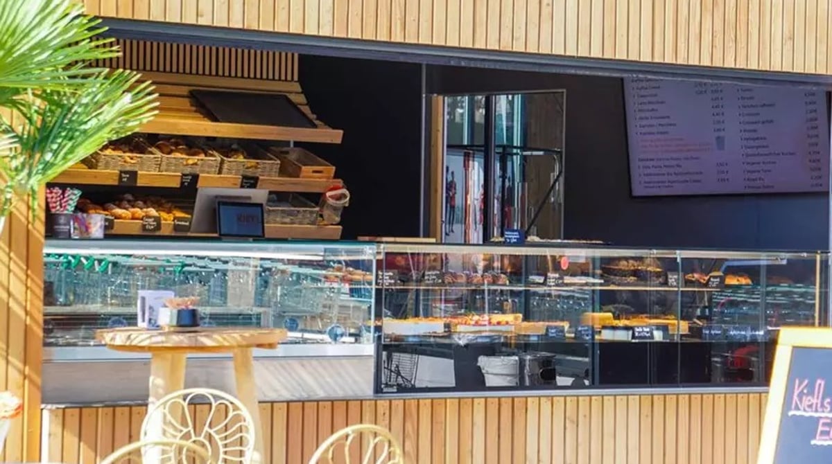 Theke der Kiefl To-Go-Bar mit Gebäck, Kuchen und Tafel mit Getränkepreisen