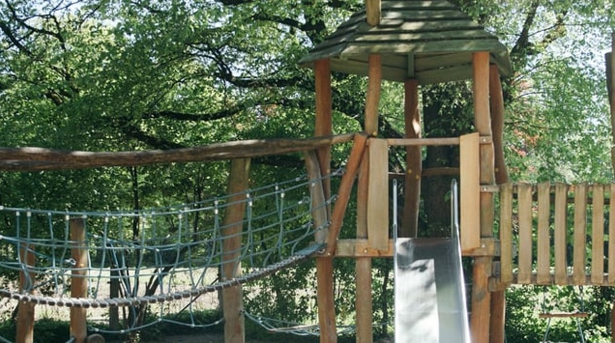 Spielplatz mit Klettergerüst aus Holz gegenüber dem Biergarten