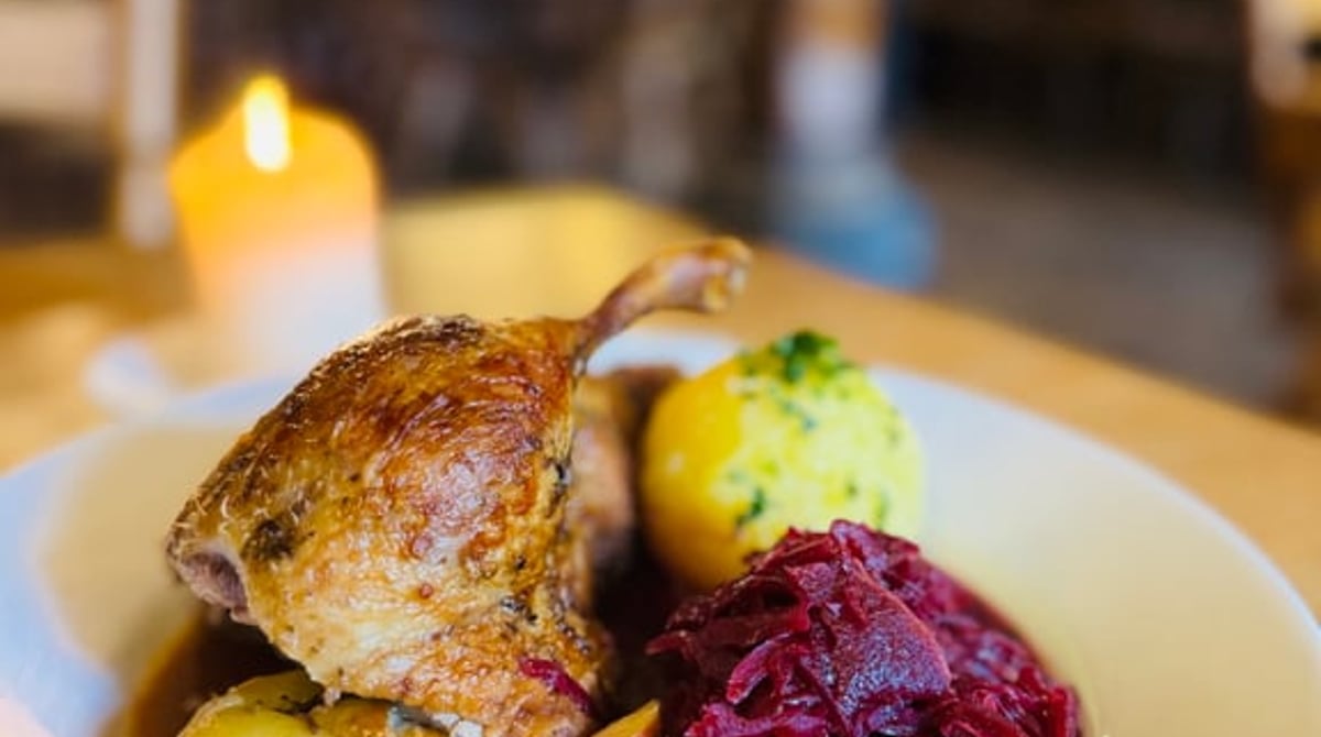 Gebratene Ente mit Blaukraut, Kartoffelknödel und Bratapfel im Wirtshaus im Fraunhofer