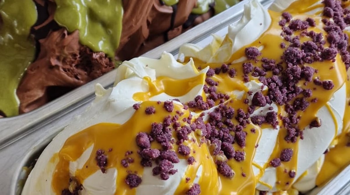 Eiswannen mit Schokoladeneis unter Pistaziensauce und Vanilleeis mit Mangosauce und Beerenstreuseln