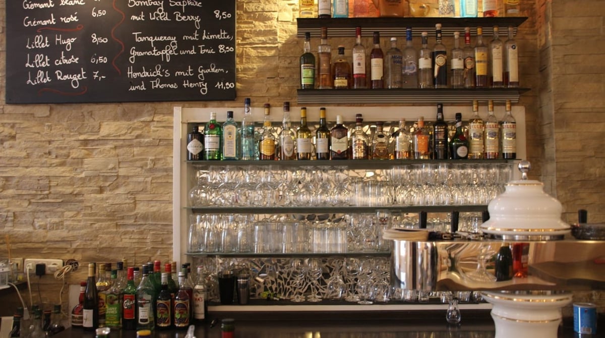 Bar der Maison Massard mit Kreidetafel, Flaschenregal, Gläsern und Zapfanlage