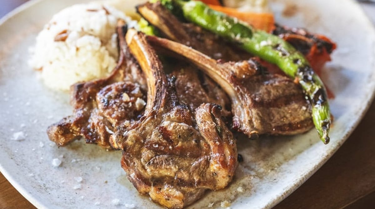 Gegrillte Lammkoteletts mit Reis und gegrillter Paprika auf einem Teller