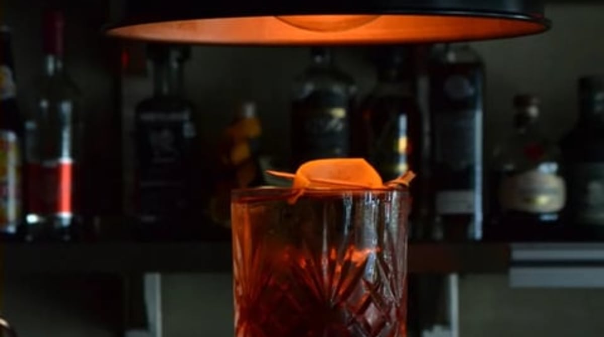 Cocktail mit Orangenzeste im Kristallglas vor der Bar des MOSTROS