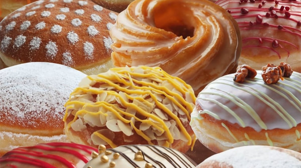 Bunte Krapfen mit Glasur, Streuseln und Puderzucker