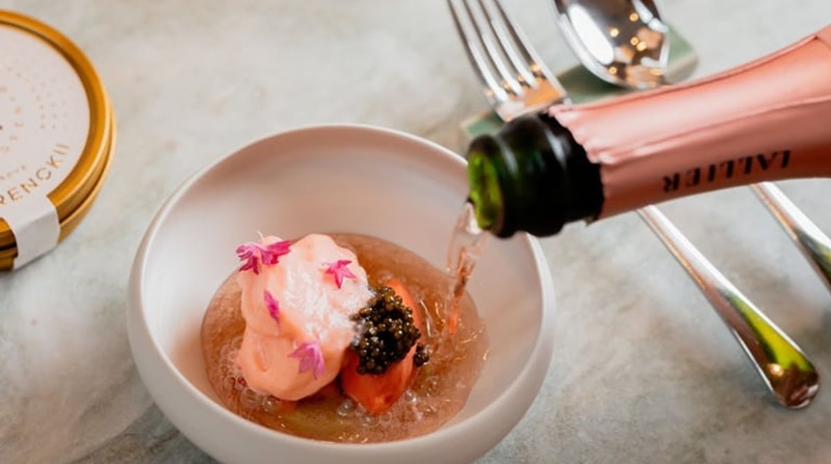 Dessert mit Kaviar in einer Schale, daneben wird Rosé-Champagner eingegossen
