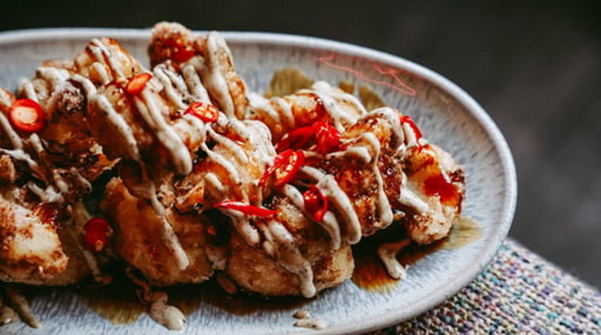 Frittierte Häppchen mit Mayonnaise und Chili auf einem Teller