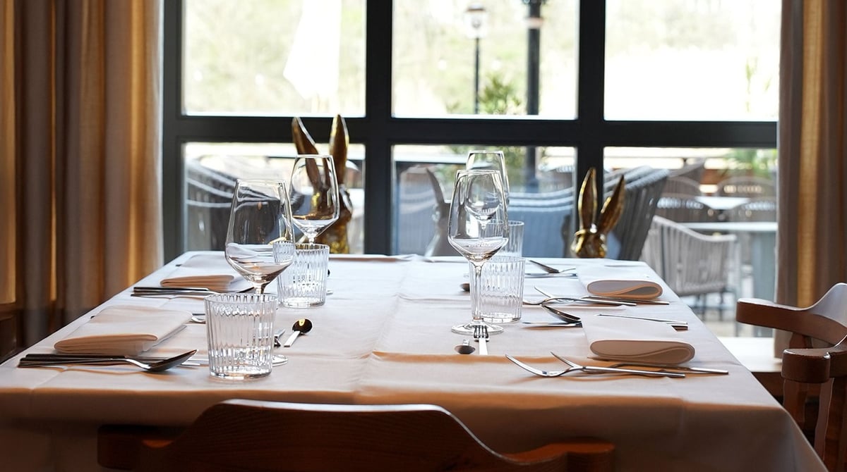 Gedeckter Tisch im Wirtshaus vor großen Fenstern