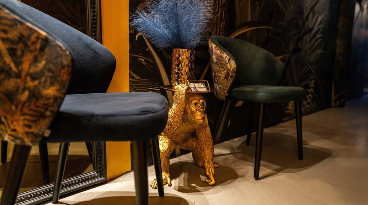 Samtstühle und eine goldene Gorillafigur im Gastraum