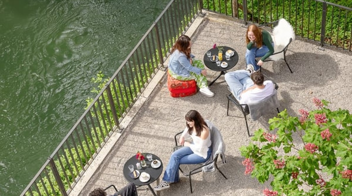 Gäste auf der Terrasse direkt über dem Auer Mühlbach, von oben gesehen