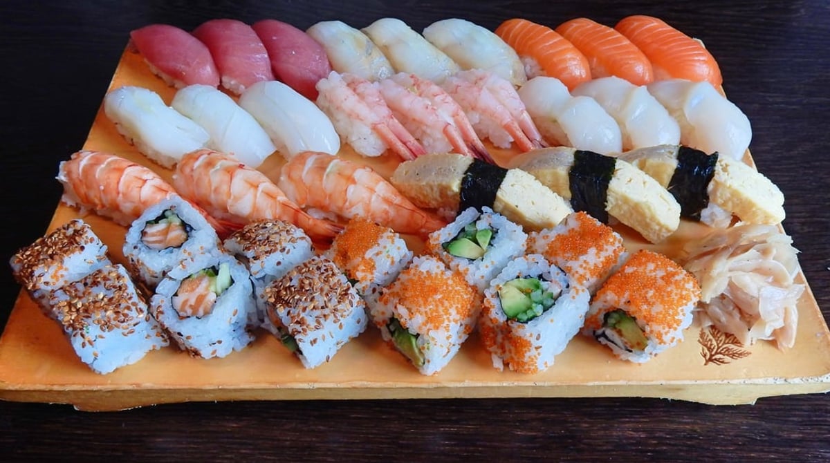 Große Sushi-Platte mit Nigiri und Rollen auf einem Holzbrett im Kaito