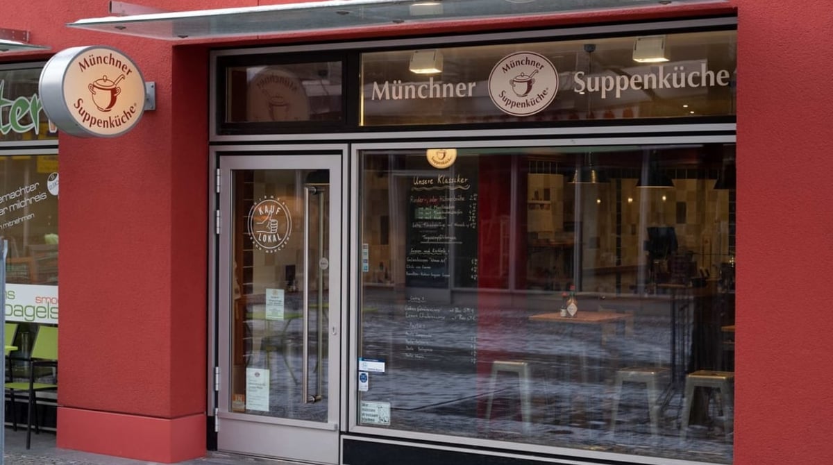 Eingang der Münchner Suppenküche mit rotem Vordach und Schild