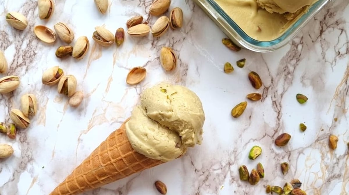 Pistazieneis in der Waffel zwischen Pistazien und einer Schale mit Eis