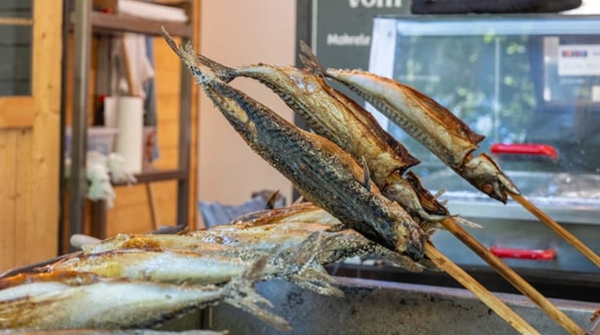 Makrelen auf dem Steckerlfisch-Grill über Glut am Stand Fisch & Flamme