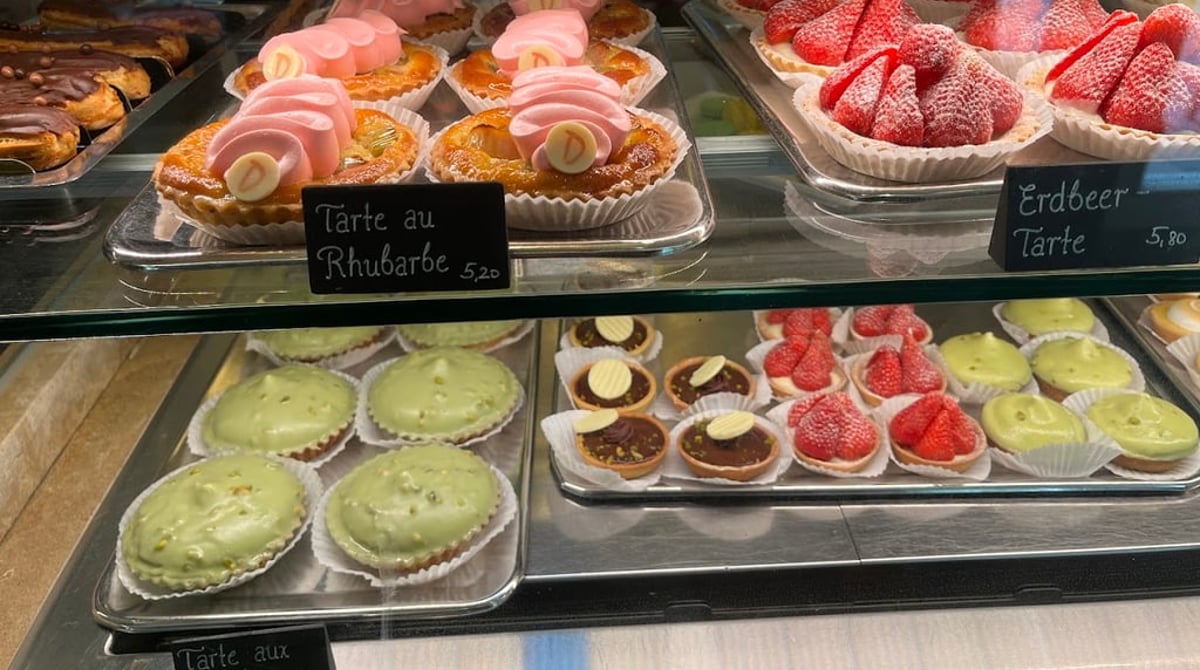 Vitrine mit Rhabarber-, Erdbeer- und Pistazien-Tartelettes und Éclairs
