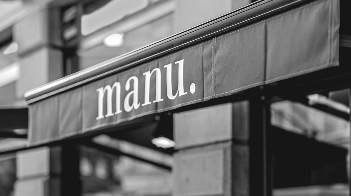 Schriftzug manu. auf der Markise der Weinbar an der Rumfordstraße