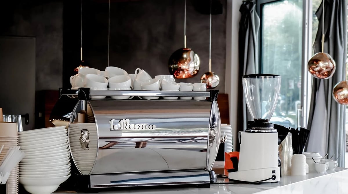 Siebträger-Espressomaschine und Kupferleuchten hinter dem Tresen von Wagners Juicery