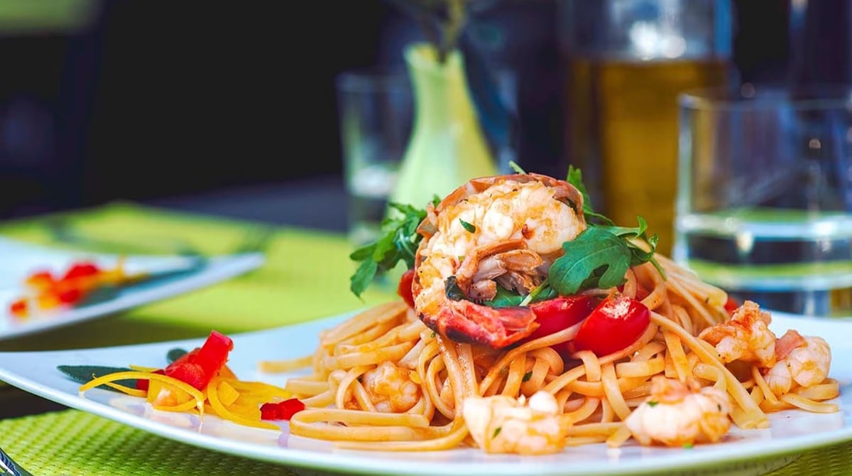 Spaghetti mit Garnelen und Paprika auf einem Teller im Cupido