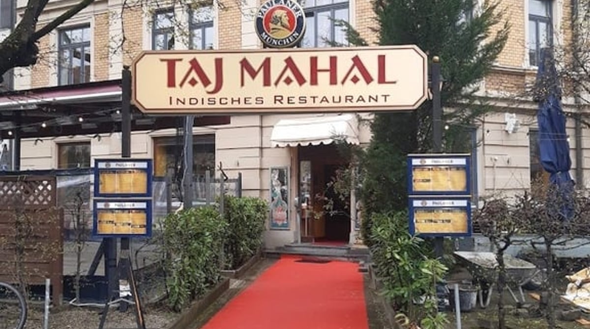 Eingang des Taj Mahal an der Nymphenburger Straße mit rotem Teppich, Schild und Vorgarten