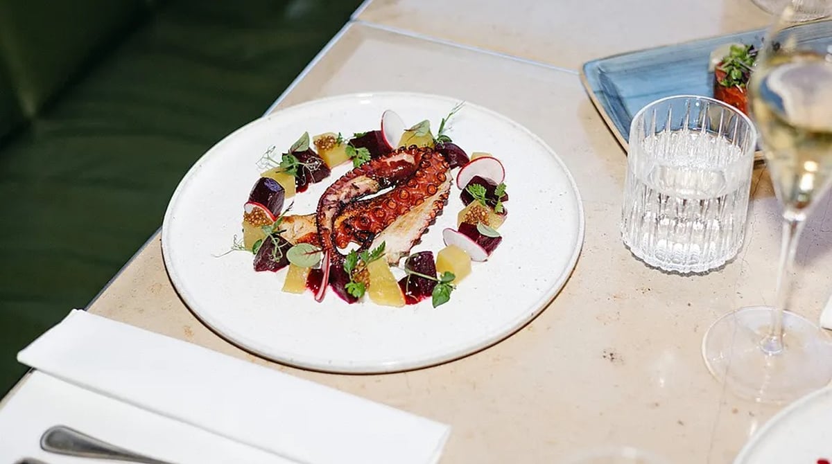 Gegrillter Pulpo mit Roter Bete und Orange auf einem weißen Teller
