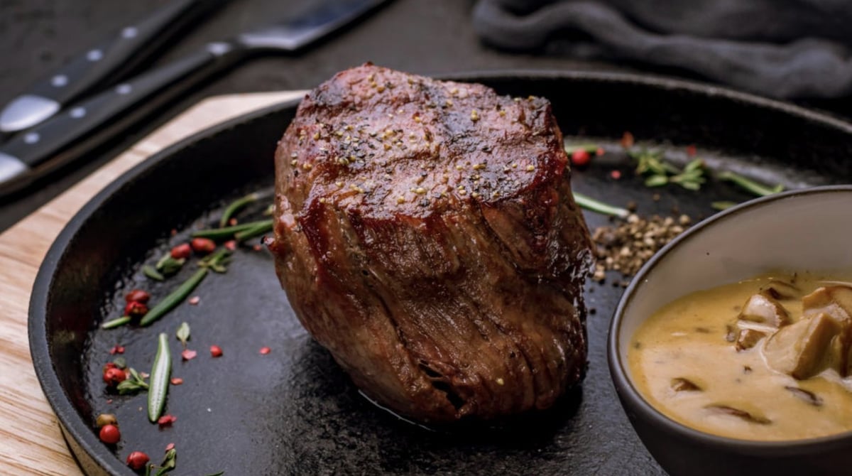 Rinderfilet auf einer Gusspfanne mit Pilzsauce, Rosmarin und rosa Pfeffer