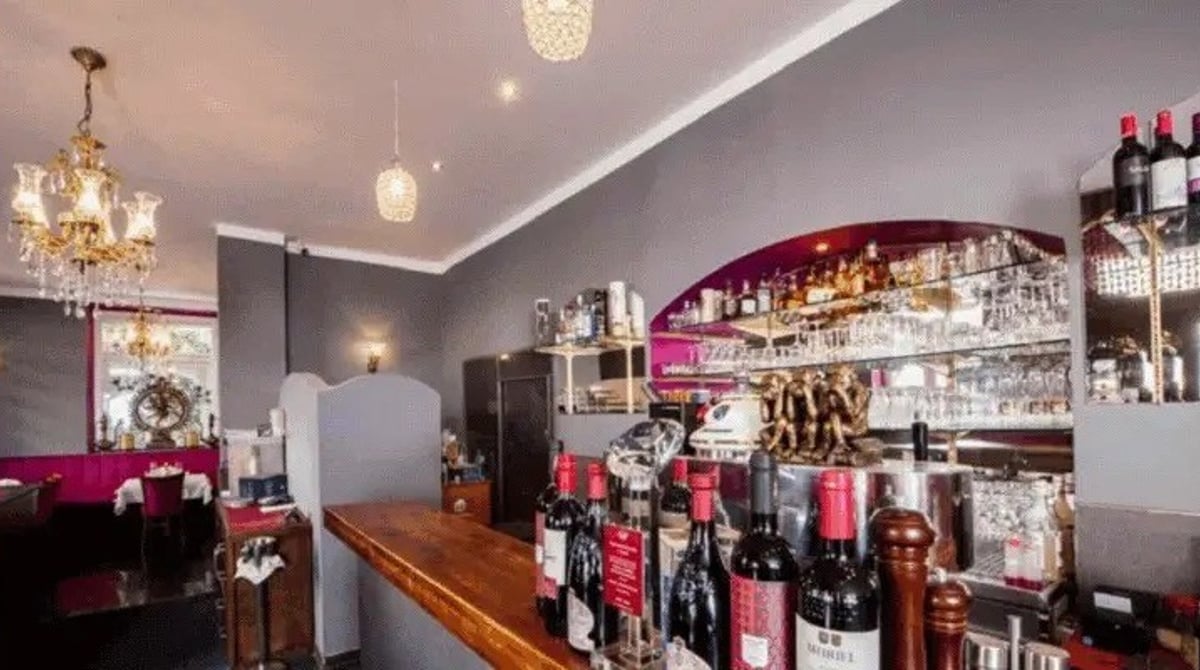 Bar mit Weinflaschen, Gläsern und Kronleuchter im Royal India