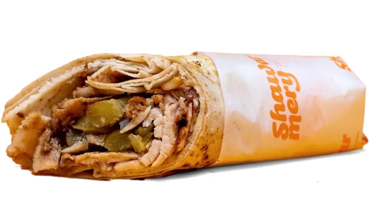 Shawarma Classic der Shawarmery: Chicken Shawarma mit Pickles im Wrap, halb in Papier mit Logo gewickelt