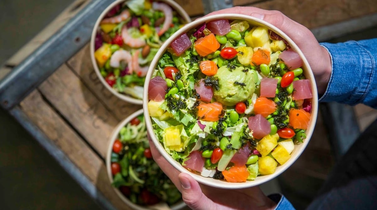 Poke Bowl mit Thunfisch, Lachs, Mango, Edamame und Avocado-Creme, daneben weitere Bowls
