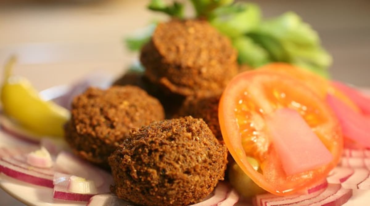 Falafel mit Tomate, Zwiebeln und Peperoni auf einem Teller im Sababa
