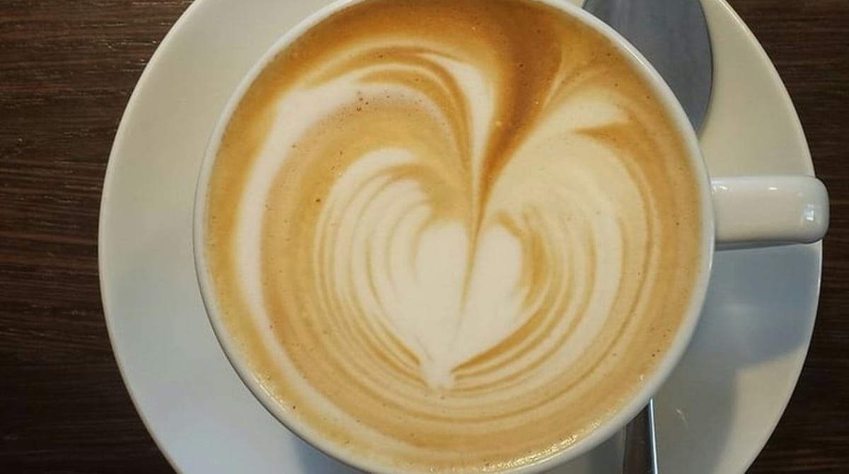 Cappuccino mit Herzmotiv im Milchschaum, von oben fotografiert