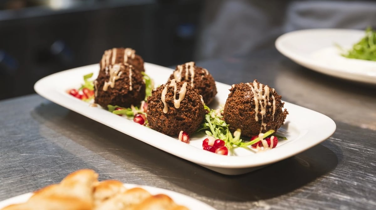 Länglicher Teller mit Falafel-Bällchen und Granatapfelkernen im Orta