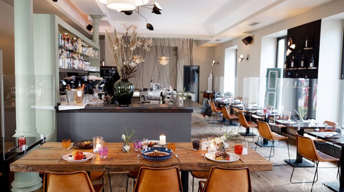 Heller Gastraum mit Holztischen und Bar im Levante in Schwabing