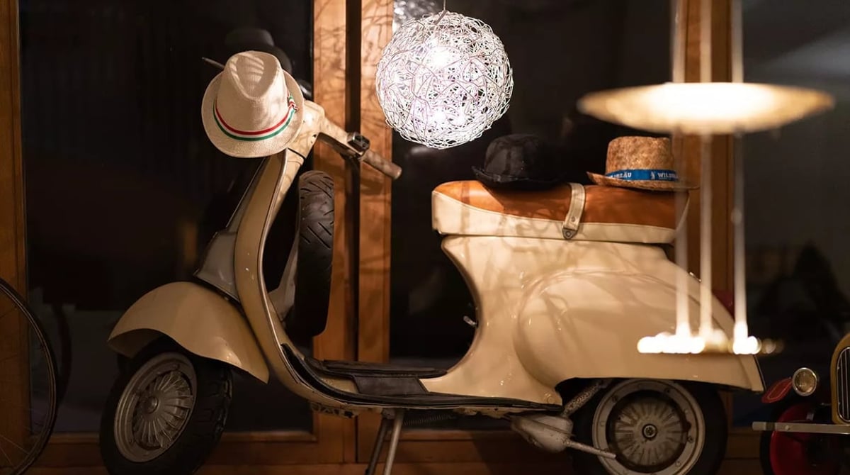 Vespa mit Hüten unter einer Kugelleuchte als Dekoration im PURO bar e cucina