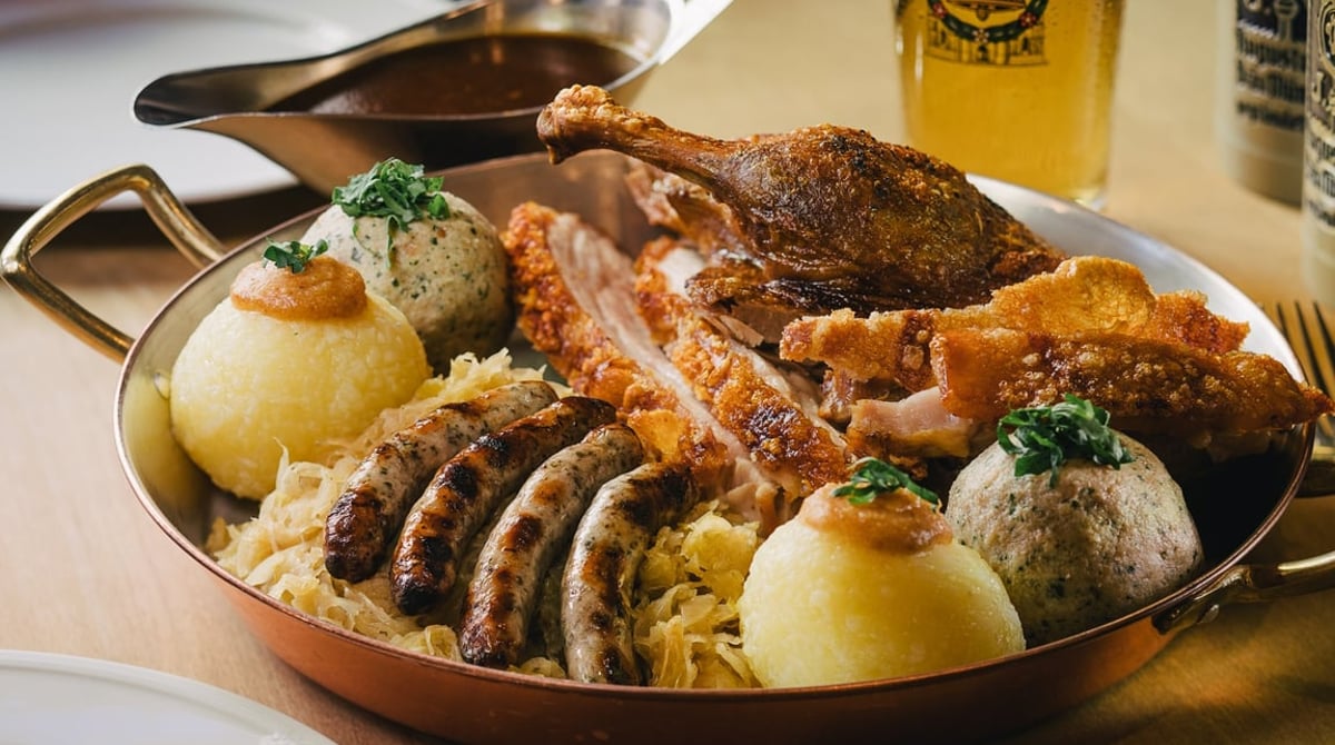 Gemischte Platte mit Bratwürstl, Braten und Knödeln auf Sauerkraut im Bratwurst Glöckl