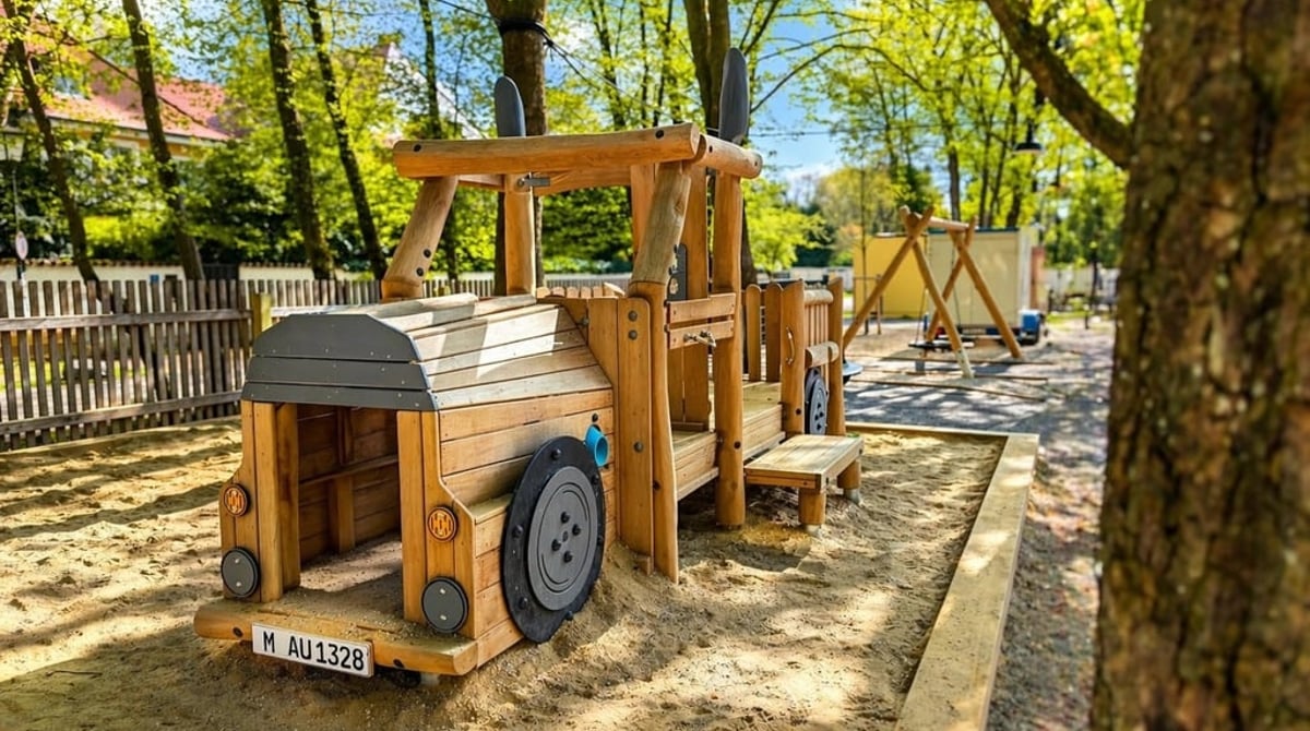 Spielplatz im Biergarten mit Holztraktor im Sandkasten