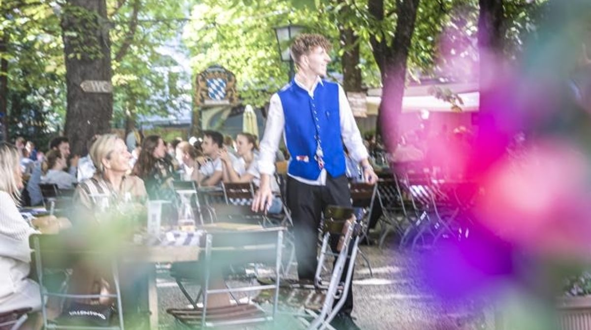 Bedienung im Biergarten des Hofbräukellers zwischen Kastanien und Blumen