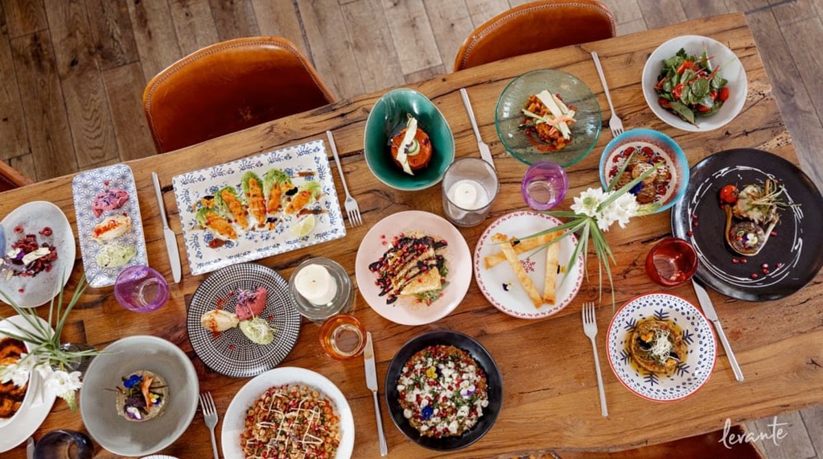 Holztisch mit vielen kleinen Mezze-Tellern im Restaurant Levante